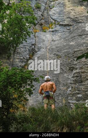 person in special equipment and helmet climbing a rock. Alpinist sport. Outdoor activity. extreme sport Stock Photo