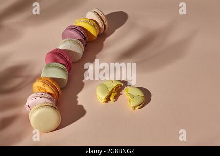 Whole macarons arranged in line and one broken cookie Stock Photo