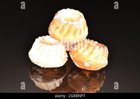 Three homemade sweet cupcakes, close-up, isolated on black. Stock Photo