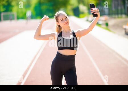 Beautiful fitness woman taking selfie at sport ground Stock Photo