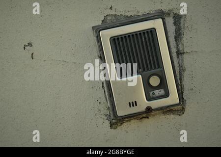 A broken intercom communication panel on a dirty wall Stock Photo