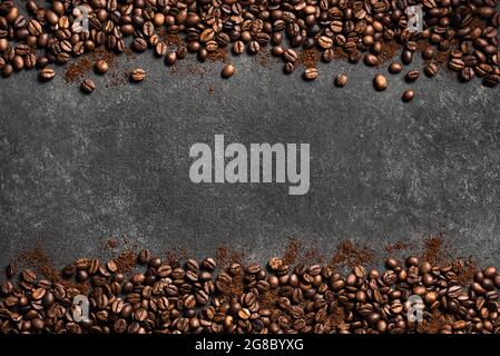 Coffee beans and ground coffee on black background, top view, copy space. Roasted  coffee concept border. Stock Photo
