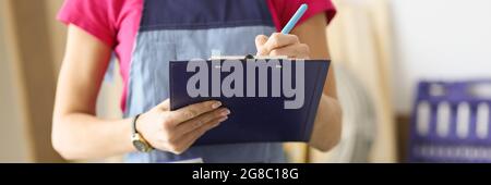 Woman repairman writing paper on clipboard closeup Stock Photo