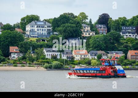 Hamburg, Germany - apartment buildings on the sandy Elbe beach in the affluent residential area in Othmarschen, a harbour ferry in front, the liner Re Stock Photo