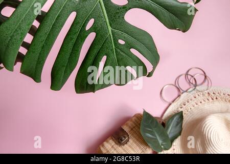 Close-up of natural leaf and women's accessories on a pink background, top view. Stock Photo