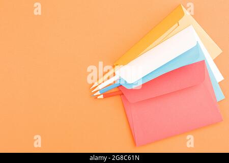 Colored postage envelopes with colored pencils. Stock Photo
