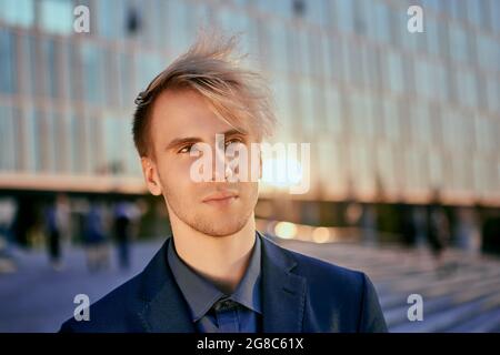 Young trainee in business suit in front of an office building. Stock Photo