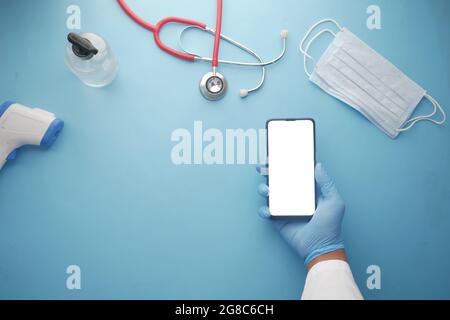 doctor hand holding smart phone with blank screen on clinic desk  Stock Photo