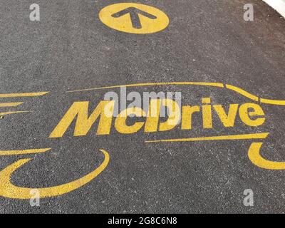 PESCARA, ITALY - Jul 07, 2021: A Mcdrive logo with an arrow on the asphalt near a McDonald's in Pescara, Italy Stock Photo