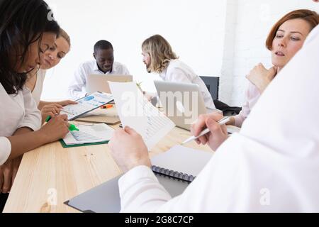 Confident businessmen and businesswomen sitting and working. Business people sitting around the desk in a meeting Stock Photo