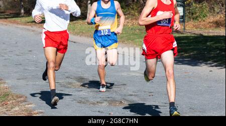 Thre high school boys competing in a cross country running race on a gravel path at Van Cortlandt park in the Bronx. Stock Photo