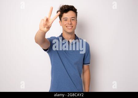 Happy young man with victory sign isolated over white background. Stock Photo