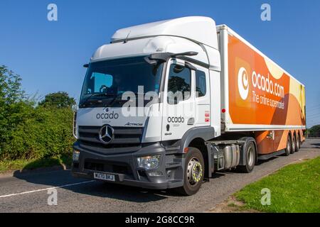 Ocado Van livery & Morrisons supermarket grocery delivery service food store vehicles; online delivery fleet delivering, groceries & household essentials in Cheshire, UK Stock Photo