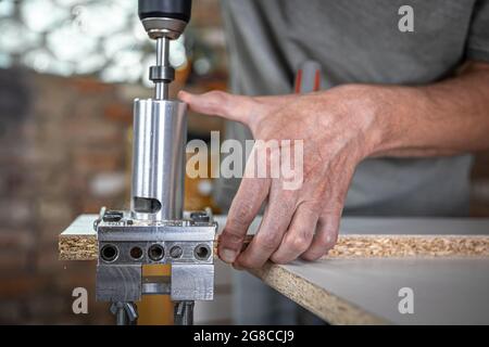 The carpenter works as a professional tool for drilling wood. Stock Photo