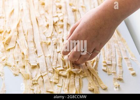 Close-up of the process of making homemade pasta. Female chef prepares fresh traditional Italian pasta Stock Photo