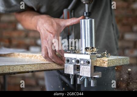 The carpenter works as a professional tool for drilling wood. Stock Photo