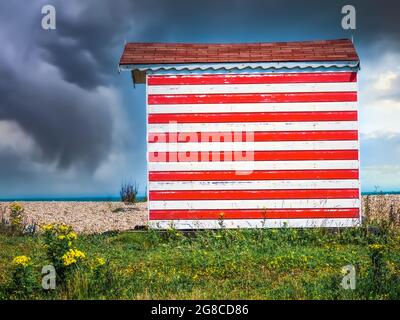 Red and white beach hut by the sea in Greatstone Kent Stock Photo