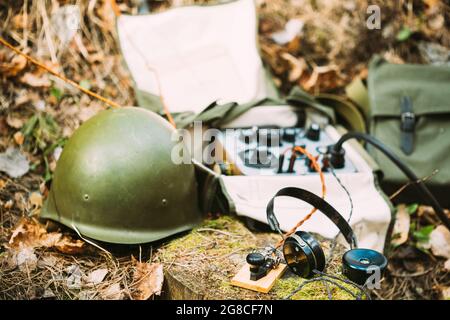 Russian Soviet Portable Radio Transceiver Used By USSR Red Army Signal Corps In World War Ii. Headphones, Telegraph Key And Helmet Are On A Forest Stock Photo