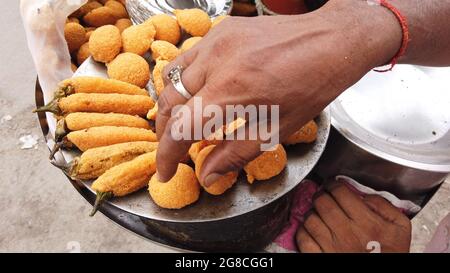 Closeup of a hand preparing Moong Dal Ke Ram Ladoo snack made from yellow lentil and Bengal gram Stock Photo