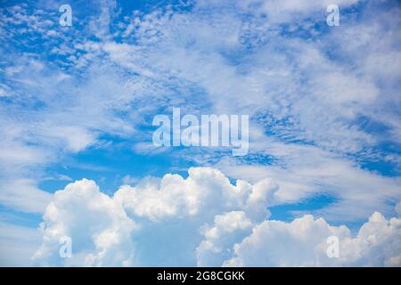 Beautiful white fluffy and feathery clouds against the blue sky. Natural delicate background for text. Stock Photo