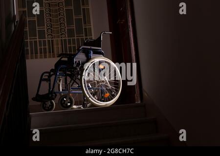 Wheelchair at the top of a flight of stairs Stock Photo