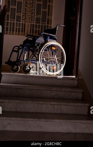 Wheelchair at the top of a flight of stairs Stock Photo