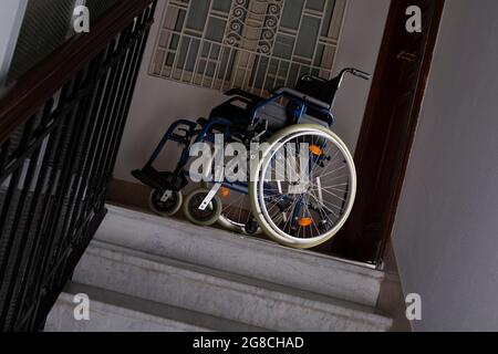 Wheelchair at the top of a flight of stairs Stock Photo