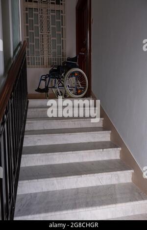 Wheelchair at the top of a flight of stairs Stock Photo