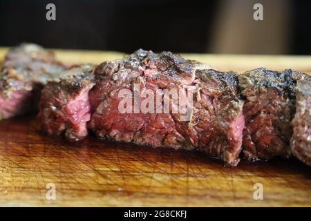 Fraldinha. Grilled BBQ Brazilian Steak Meat in Barbecue steak. Meat being cut on a wooden board. Stock Photo