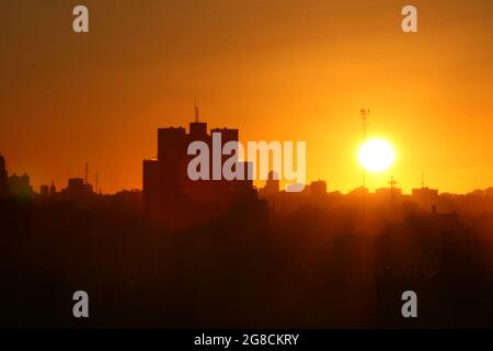 the buildings with the orange sun behind, backlight Stock Photo