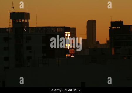 the buildings with the orange sun behind, backlight Stock Photo