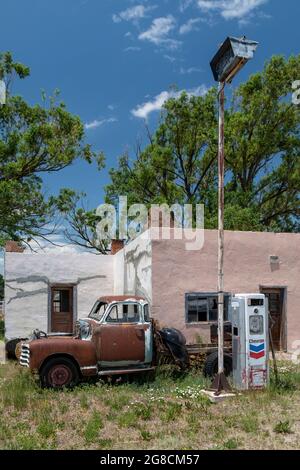 La Jara, Colorado, A rusty, old pickup truck, parked in front of an old Chevron gas station, in southern Colorado. Stock Photo