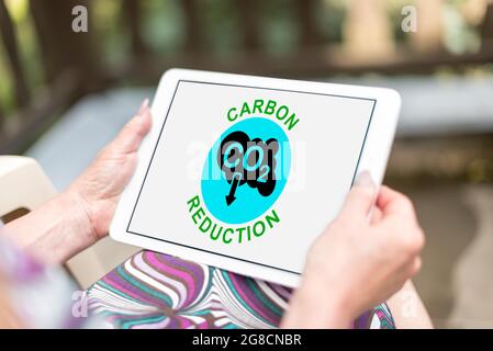 Carbon reduction concept shown on a tablet held by a woman Stock Photo