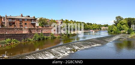 Chester, England - July 2021: Panoramic view of the River Dee, which flows through the city. In the foreground is a weir and fish pass. Stock Photo