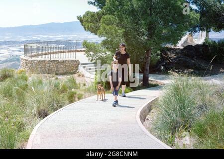 boy with his mom and puppy smiling as they walk back from the lookout point in the mountains Stock Photo