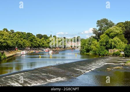 Chester, England - July 2021: Scenic view of the River Dee, which flows through the city. In the foreground is a weir and fish pass. Stock Photo