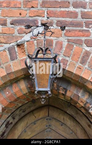 An antique lamp hanging on a brick wall. Summer. Stock Photo