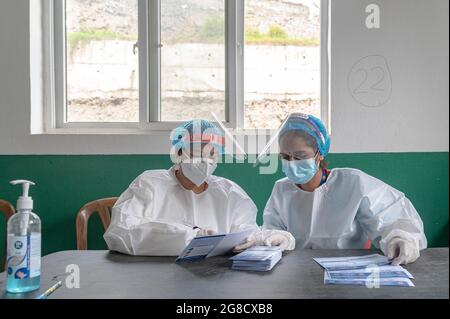 Kathmandu, Nepal. 19th July, 2021. Health workers wearing Personal Protective Equipment suits (PPE) seen preparing the vaccination cards at the municipality hospital in Mulpani.People aged between 50-54 are vaccinated till July 21 which includes disabled, sanitation workers and foreign migrant workers from Nepal where this American Vaccine is being approved by the particular country. Nepal received 1.634 million doses of J & J vaccine from the US on July 12th, through COVAX, an international vaccine sharing scheme. Credit: SOPA Images Limited/Ģ����ý Live News Stock Photo