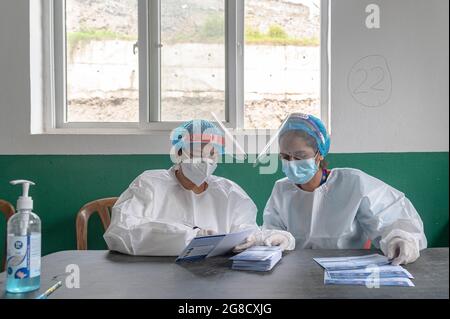 Health workers wearing Personal Protective Equipment suits (PPE) seen preparing the vaccination cards at the municipality hospital in Mulpani.People aged between 50-54 are vaccinated till July 21 which includes disabled, sanitation workers and foreign migrant workers from Nepal where this American Vaccine is being approved by the particular country. Nepal received 1.634 million doses of J & J vaccine from the US on July 12th, through COVAX, an international vaccine sharing scheme. (Photo by Dipendra Rokka/SOPA Images/Sipa USA) Stock Photo