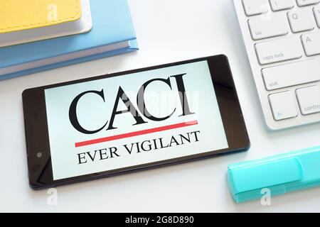KYIV, UKRAINE - June 30, 2021. CACI ever vigilant International Inc logo on the tablet. Stock Photo