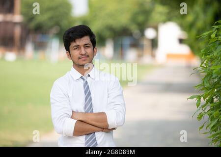 Front facing portrait of young Male student in campus with negative space Stock Photo