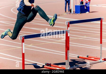 girl athlete run hurdles track and field race Stock Photo