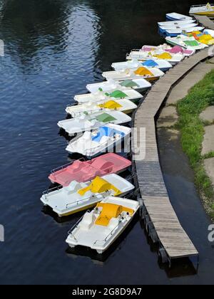 long wooden pier with many colorful vivid catamarans boats on a river Dnipro in Kyiv, Ukraine Stock Photo