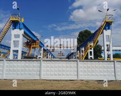 loading crane - industrial equipment for lifting cargo for shipping at facility factory or shipping docks  Stock Photo