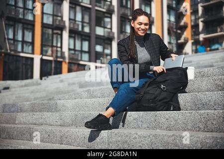 High-spirited good-looking lady reaching for her laptop Stock Photo