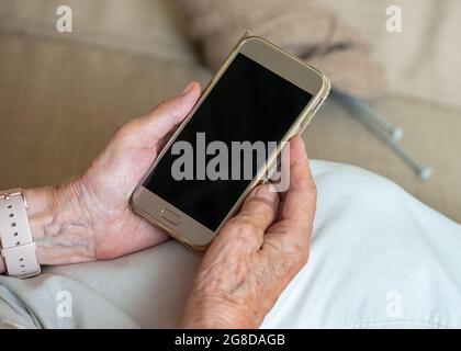 Senior woman's hands holding blank screen smartphone. Close up. Copy space, mockup. Stock Photo