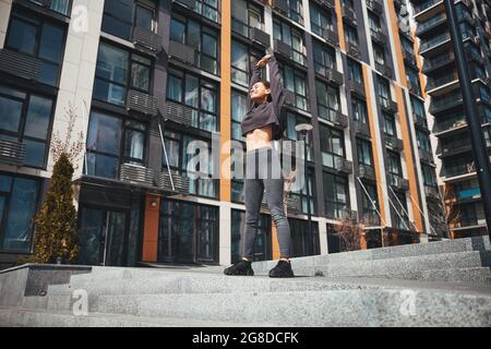 Cute joyous woman performing a stretching exercise Stock Photo