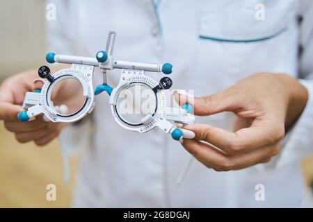 Female doctor hands holding optical trial lens frame Stock Photo