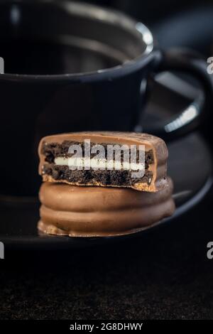 Biscuits with chocolate icing on black table. Stock Photo