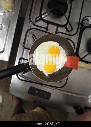 salvador, bahia, brazil - july 18, 2021: Fried eggs are seen in a frying pan on a stove in the kitchen of a house in Salvador city. Stock Photo